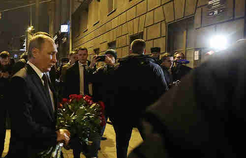Vladimir Putin lays flowers in memory of those killed in Monday's terror attack (Tass)