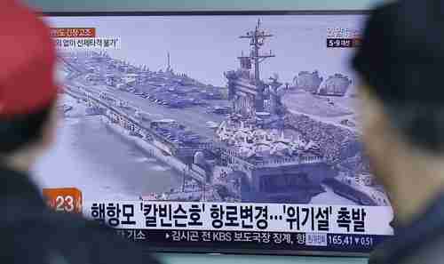 People in Seoul, South Korea, watch a TV news program showing a file image of the USS Carl Vinson aircraft carrier on Wednesday (AP)
