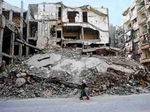 Two girls walk past destroyed buildings in Douma, Syria, part of a planned 'safe zone' (AFP)