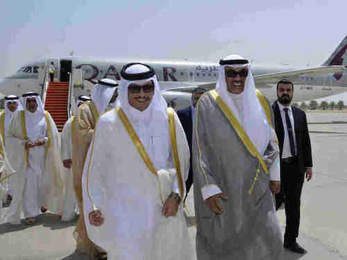 Qatar's Foreign Minister Sheikh Mohammed bin Abdulrahman Al Thani (L) and Kuwaiti Foreign Minister Sheikh Sabah Khaled Al Sabah walk together on an airport tarmac in Kuwait. (AP)