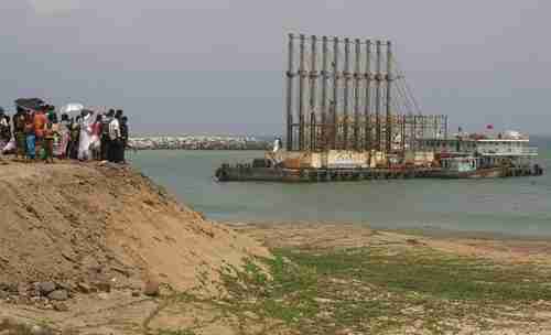 Sri Lankan citizens watch Chinese dredging ships in Hambantota port (Reuters)