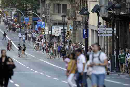 People walk down a main street on Thursday in Barcelona, where a van mounted the sidewalk and ploughed into people. (AP)