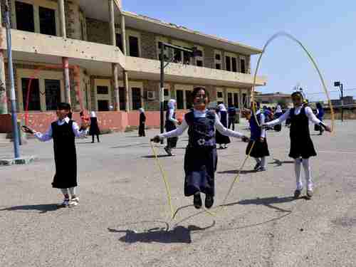 Iraqi girls play in a Mosul schoolyard (Reuters)