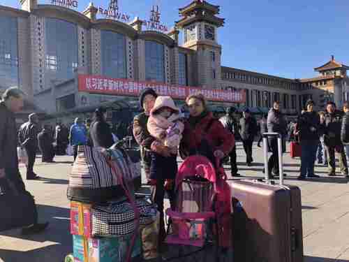 A migrant family is leaving Beijing under a government-mandated evacuation. They had 15 mins to clear all their belongings. Behind them is a big banner saying the great 'Xi Jinping new era'. (Twitter)