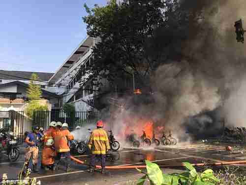 Firefighters try to extinguish a blaze following a blast at the Pentecost Church Central Surabaya in Indonesia on Sunday (Reuters)