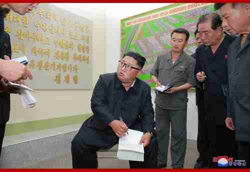 Kim Jong-un makes a big show of taking notes at a factory in this North Korean media photo