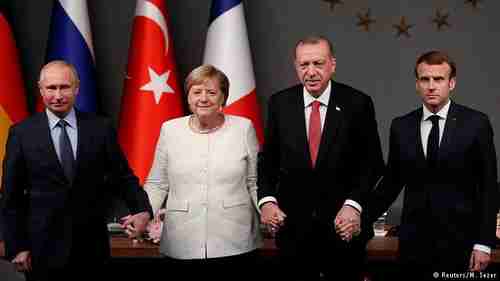 Leaders holding hands: Vladimir Putin, Angela Merkel, Recep Tayyip Erdogan, and Emmanuel Macron (Reuters)