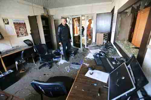 Employee inspects damage to Palestinian Authority media office in Gaza after attacks by five men (AFP)