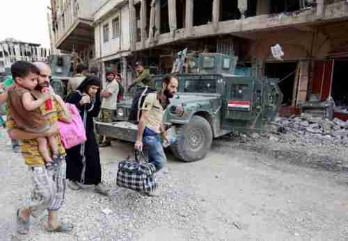 Displaced Iraqi people flee from fighting between Iraqi forces and ISIS in the Old City of Mosul on Friday (Reuters)