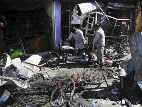 Men look at the remains of their properties at the site of the car bombing Monday in Kabul (AP)