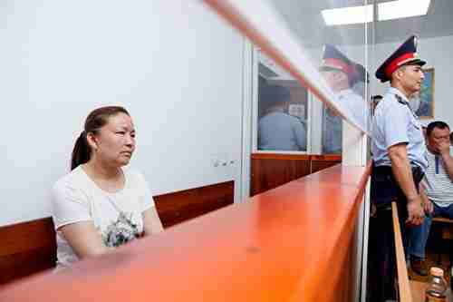 Sayragul Sauytbay, enclosed in a glass cage in courtroom, awaiting trial (AFP)